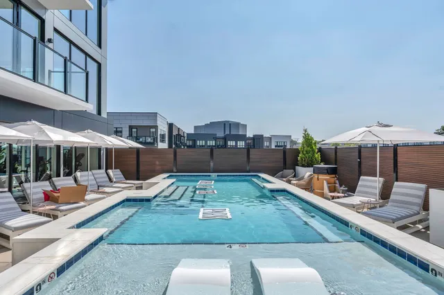 a large living room with stainless steel appliances granite countertop couches a fireplace with wooden floor