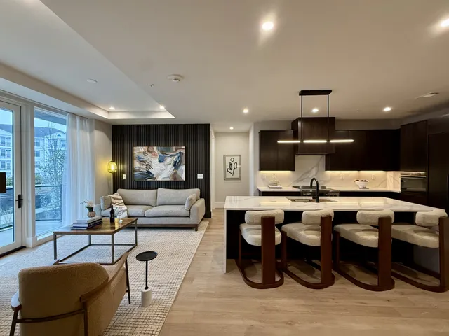 a living room with lots of furniture and view of kitchen