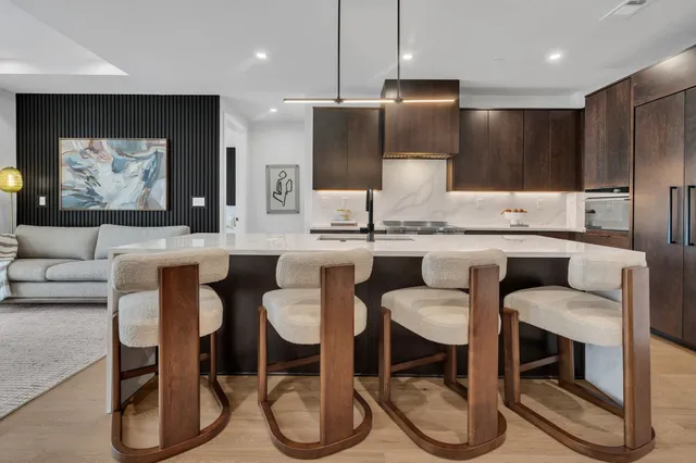 a kitchen with stainless steel appliances granite countertop a table chairs sink and microwave