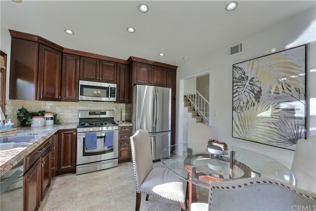 19271 Kamlyn Lane Walnut, CA 91789 - Photo 10 of 29 a kitchen with granite countertop stainless steel appliances a stove a sink dishwasher a refrigerator cabinets and couches with wooden floor