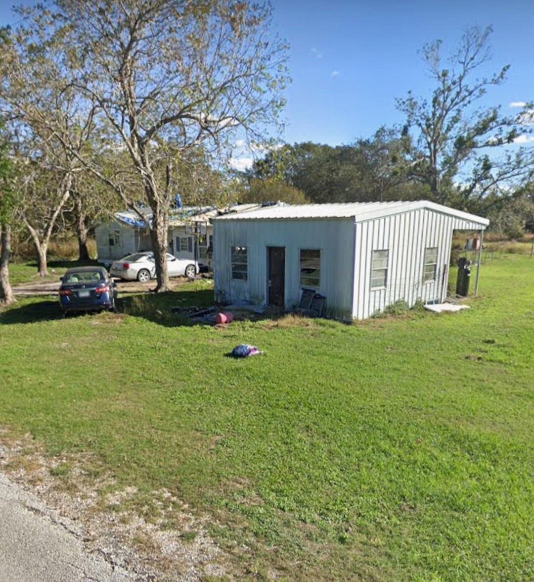 885 Bullock Road Francitas, TX 77961 - Photo 2 of 15 Distant view of a smaller secondary exterior structure/shed on the grassy lot.