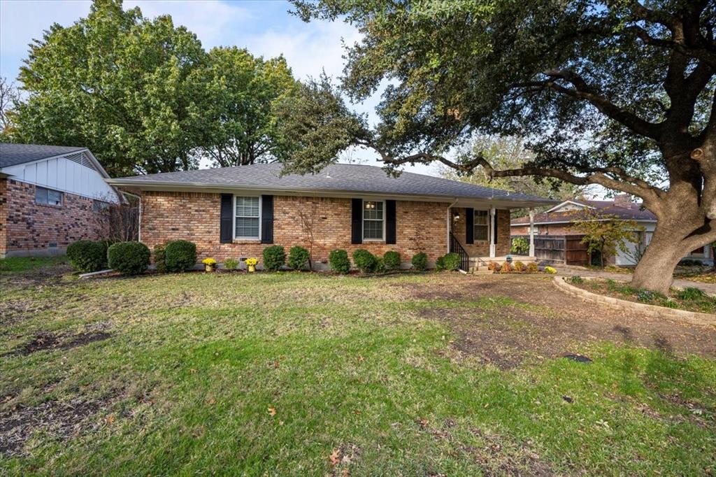 a front view of a house with a yard and trees