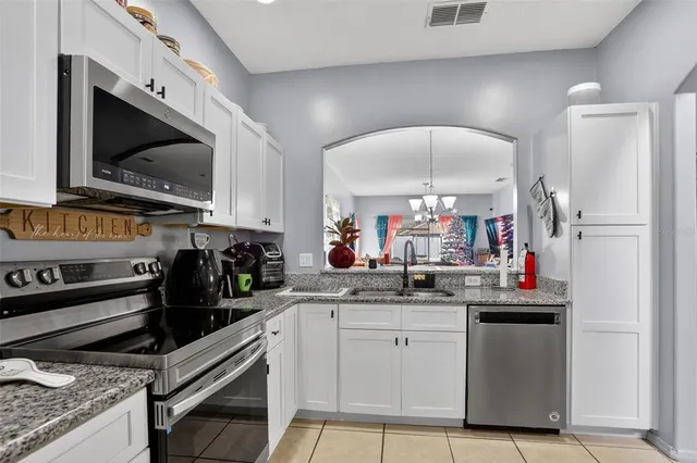 a kitchen with a sink dishwasher a stove and a refrigerator with wooden floor