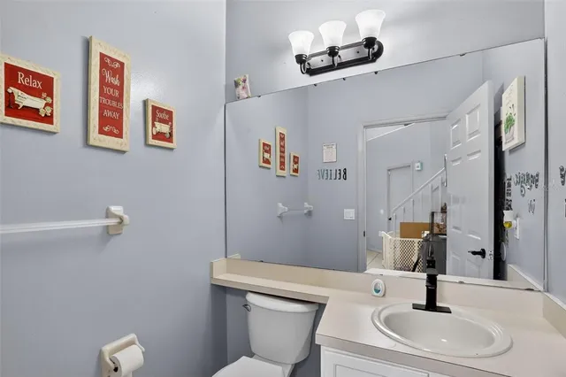 a bathroom with a sink a toilet and a mirror