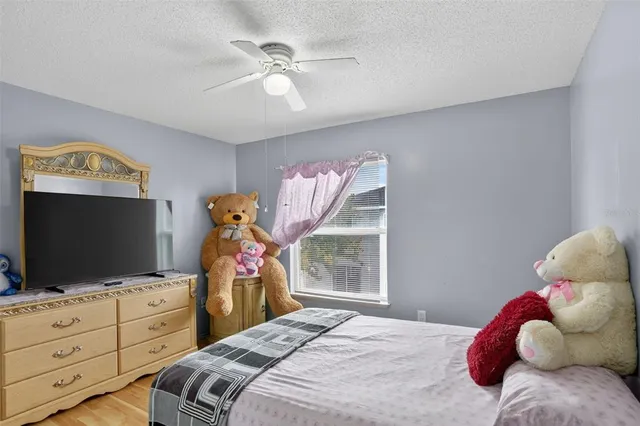 a bedroom with a bed and a flat tv screen on dresser