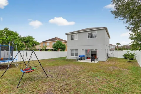a view of a house with a backyard and a tree