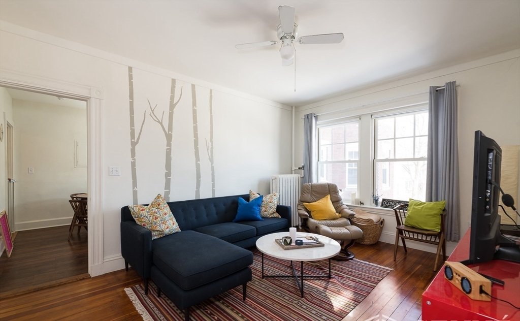 55 Magazine Street, Unit 23 Cambridge, MA 02139 - Photo 4 of 14 a living room with furniture and a flat screen tv