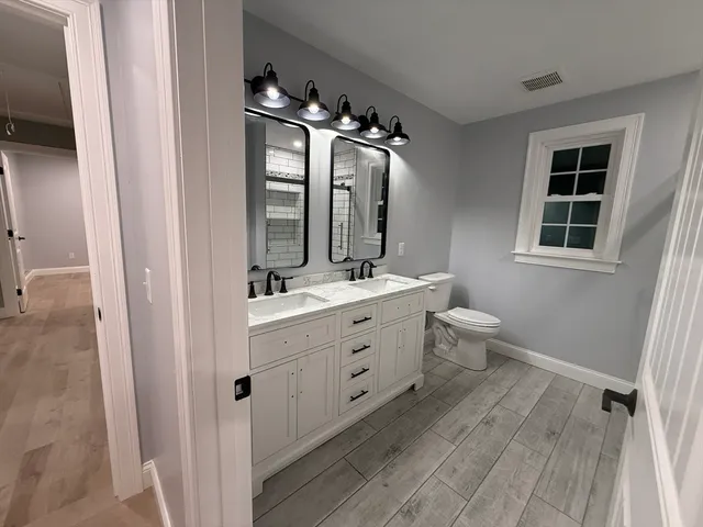wooden floor with view of bathroom