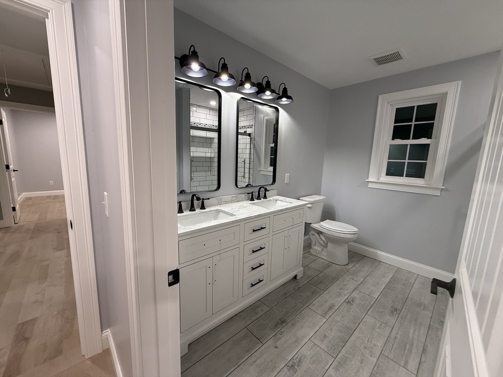 24 Cooper Road Webster, MA 01570 - Photo 24 of 42 a bathroom with a double vanity sink a toilet and a mirror