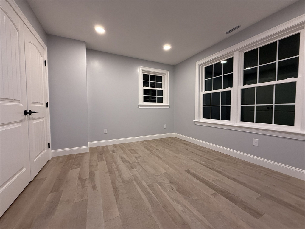 24 Cooper Road Webster, MA 01570 - Photo 33 of 42 an empty room with wooden floor and windows