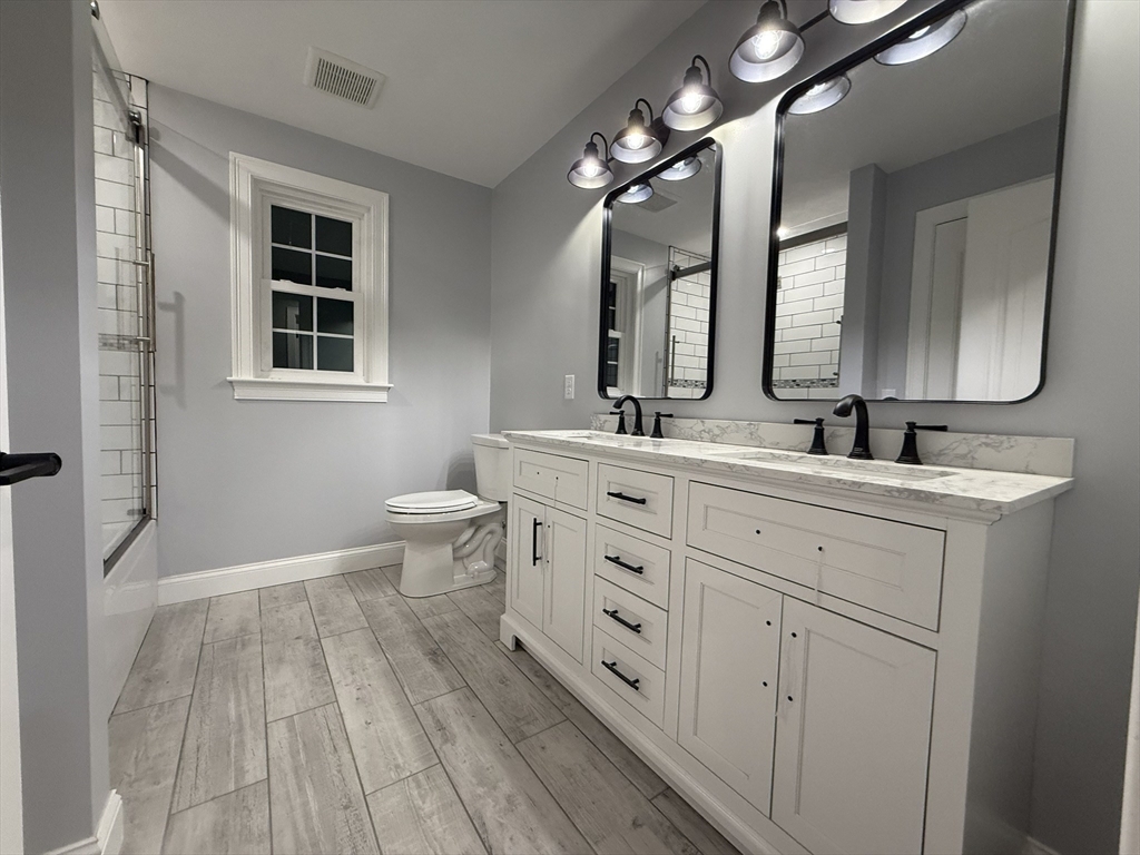 24 Cooper Road Webster, MA 01570 - Photo 37 of 42 a bathroom with a double vanity sink and a mirror