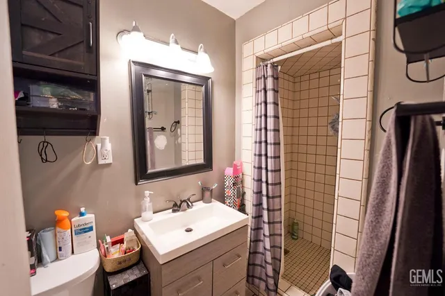 a bed room with a bed a dresser and a chandelier