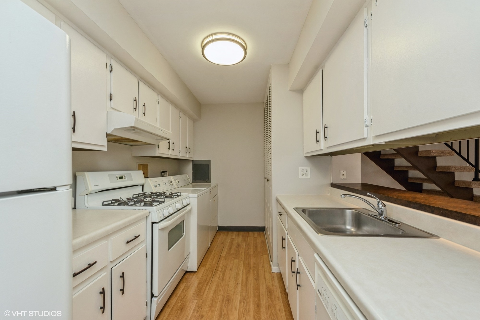 1560 Cornell Circle, Unit 31A Hoffman Estates, IL 60169 - Photo 4 of 12 a kitchen with stainless steel appliances granite countertop a sink stove oven and white cabinets with wooden floor