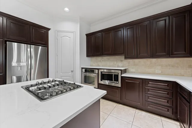 a kitchen with granite countertop wooden cabinets and stainless steel appliances