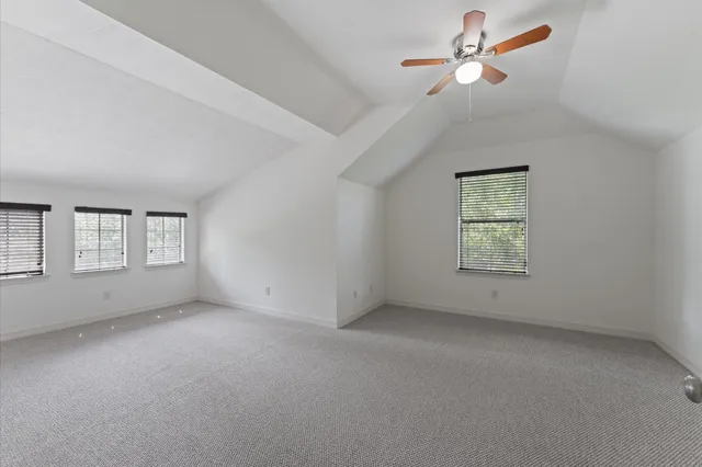 an empty room with a window and ceiling fan