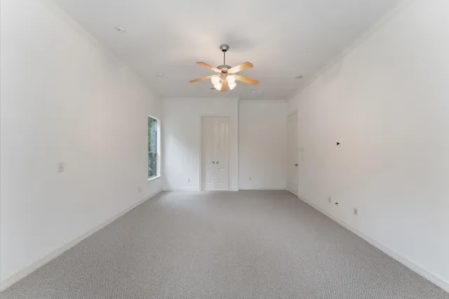 an empty room with closet and a chandelier fan
