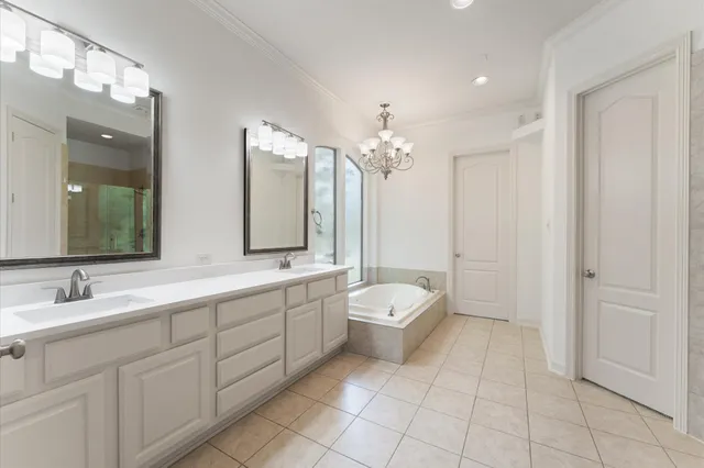 a spacious bathroom with a double vanity sink a large mirror and a
