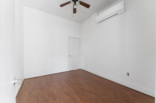 an empty room with a ceiling fan and wooden floor