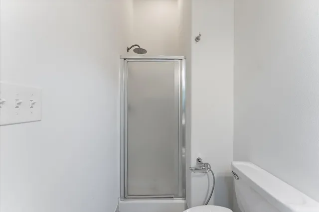 a bathroom with a granite countertop toilet and a shower