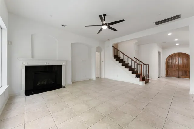 a view of empty room with fireplace and fan