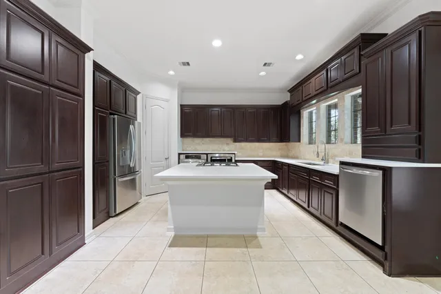 a kitchen with stainless steel appliances granite countertop a refrigerator and a stove top oven