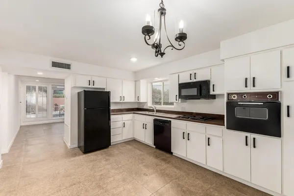 a kitchen with stainless steel appliances granite countertop a refrigerator a stove a microwave oven with cabinets and stainless steel appliances