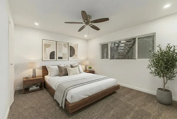 a bedroom with a bed and a potted plant