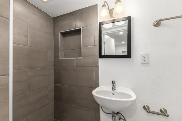 a bathroom with a sink a toilet and mirror