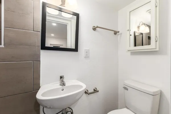 a bathroom with a toilet a sink and mirror