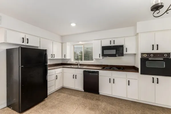 a kitchen with granite countertop a refrigerator stove and microwave