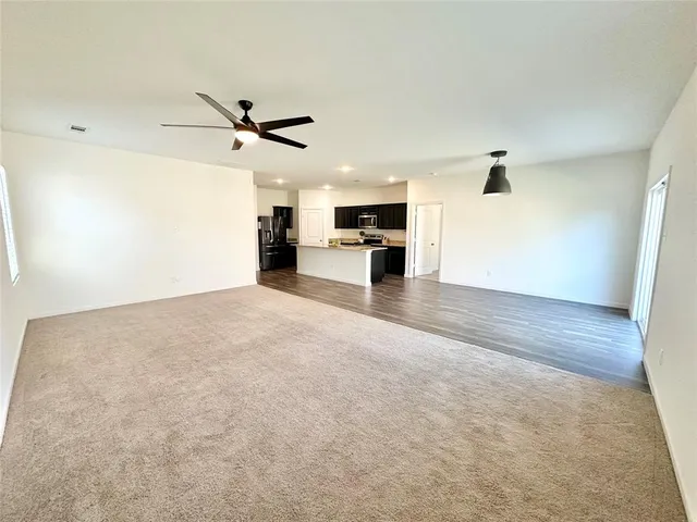 a view of a livingroom with a kitchen counter top space and appliances