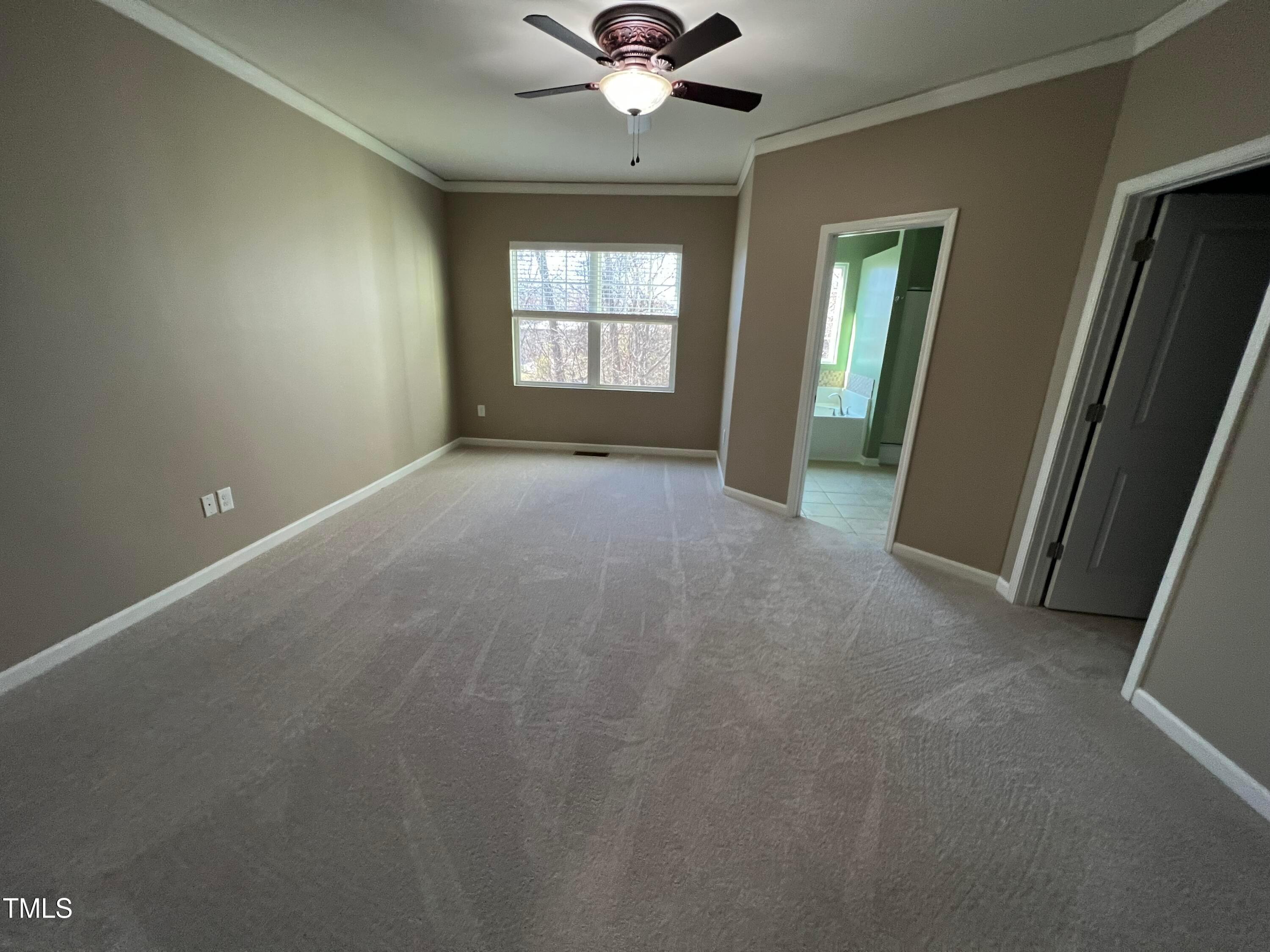 714 Treviso Lane Apex, NC 27502 - Photo 14 of 27 an empty room with chandelier fan and windows