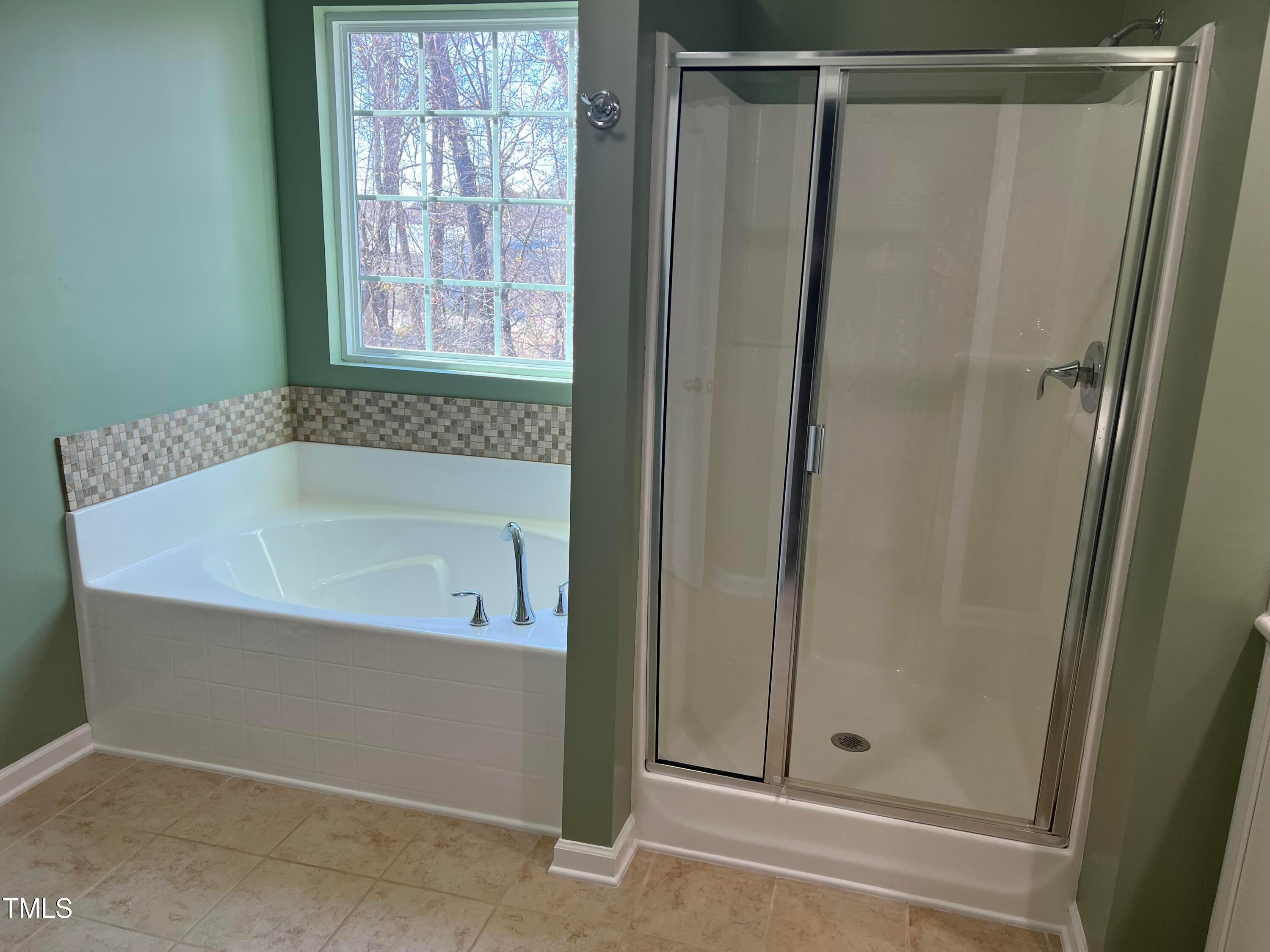 714 Treviso Lane Apex, NC 27502 - Photo 18 of 27 a bathroom with a tub and shower