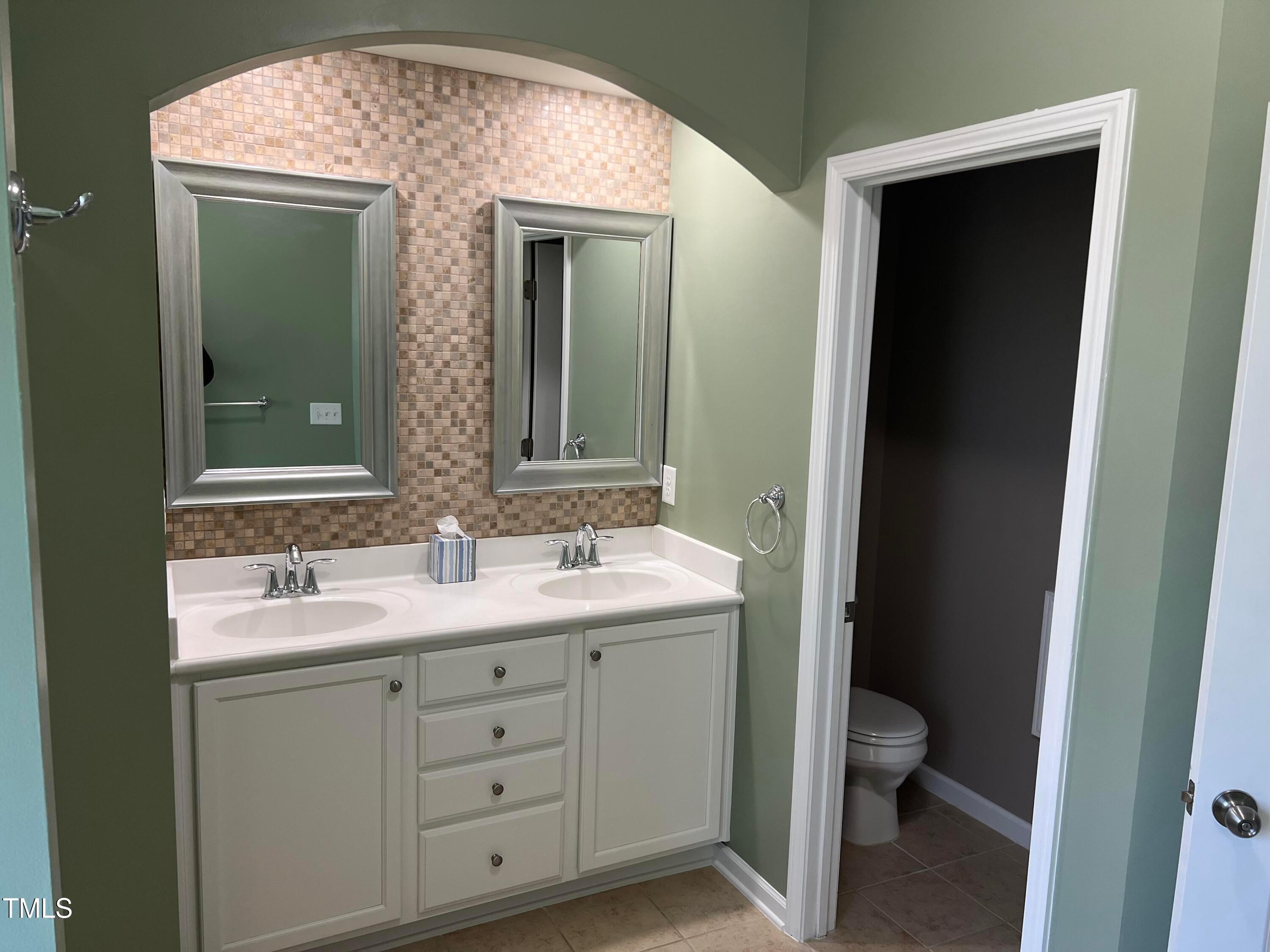 714 Treviso Lane Apex, NC 27502 - Photo 19 of 27 a bathroom with a toilet sink and mirror