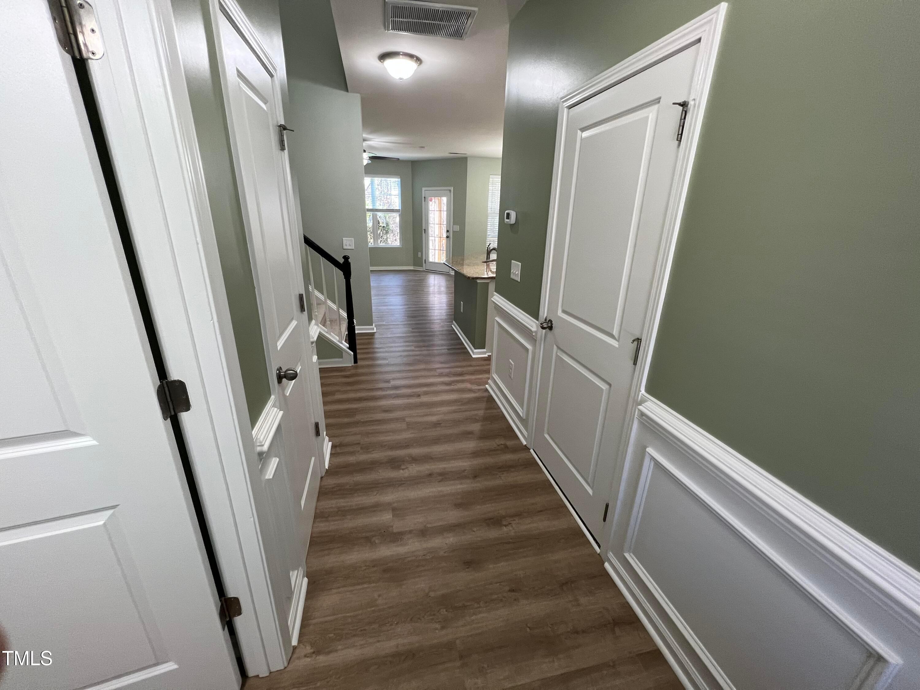714 Treviso Lane Apex, NC 27502 - Photo 4 of 27 a view of a hallway with wooden floor and stairs