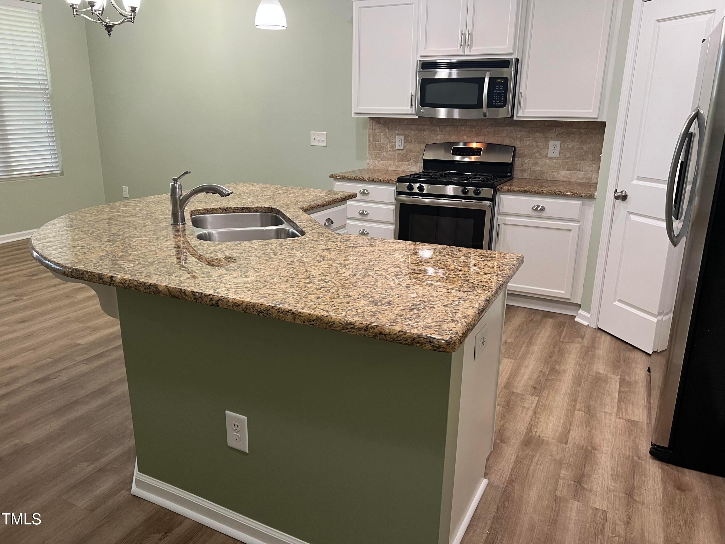 714 Treviso Lane Apex, NC 27502 - Photo 7 of 27 a kitchen with granite countertop cabinets appliances and a sink