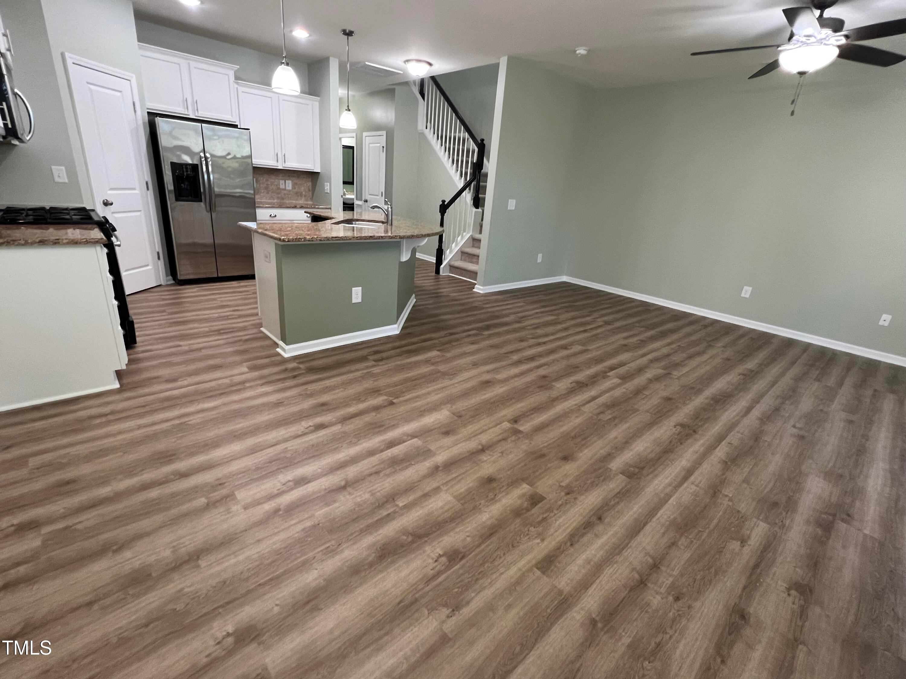 714 Treviso Lane Apex, NC 27502 - Photo 9 of 27 a view of a kitchen with furniture and a wooden floor