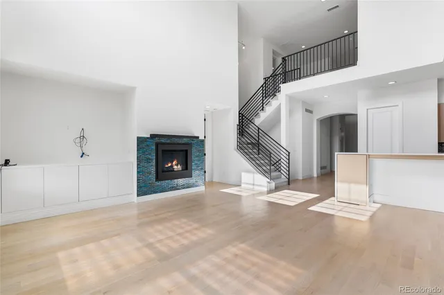 a view of an empty room with wooden floor fireplace and a window