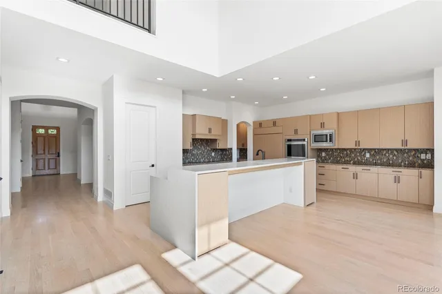 a kitchen with stainless steel appliances kitchen island granite countertop white cabinets and refrigerator