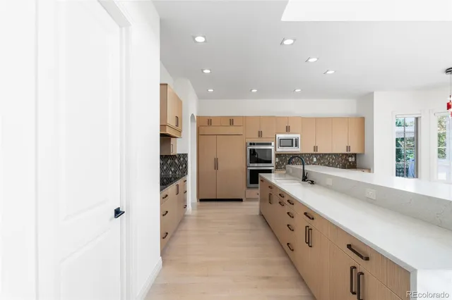 a large kitchen with a large counter top appliances and cabinets