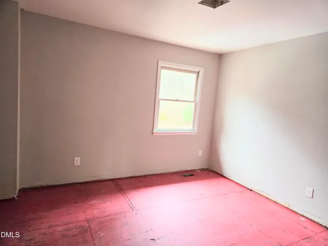 a view of an empty room with closet and wooden floor