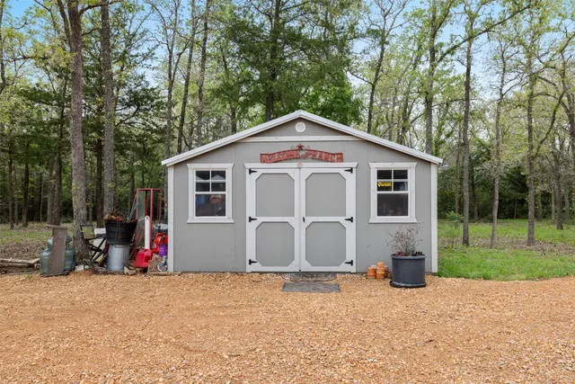 a view of a house with backyard and trees