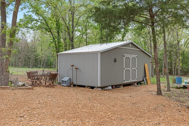 a view of a house with backyard and a tree