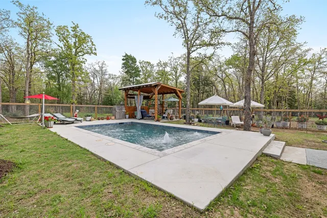 a view of a backyard with swimming pool