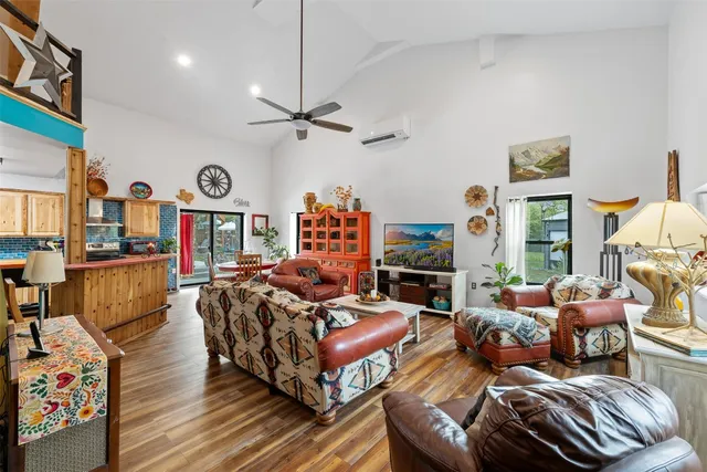 a living room with furniture a clock and a flat screen tv