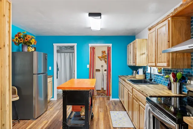 a room with stainless steel appliances kitchen island granite countertop furniture and a refrigerator