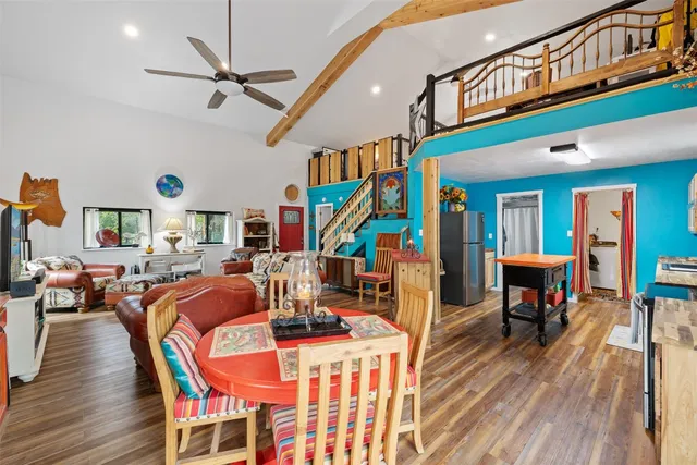 a dining room with stainless steel appliances granite countertop a dining table and chairs with wooden floor