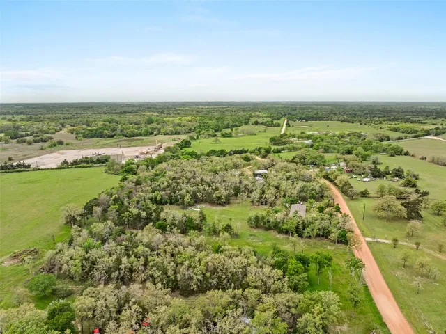 an aerial view of residential houses with outdoor space and trees