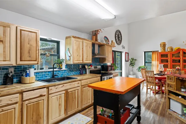 a kitchen with stainless steel appliances a stove a sink dishwasher and cabinets with wooden floor