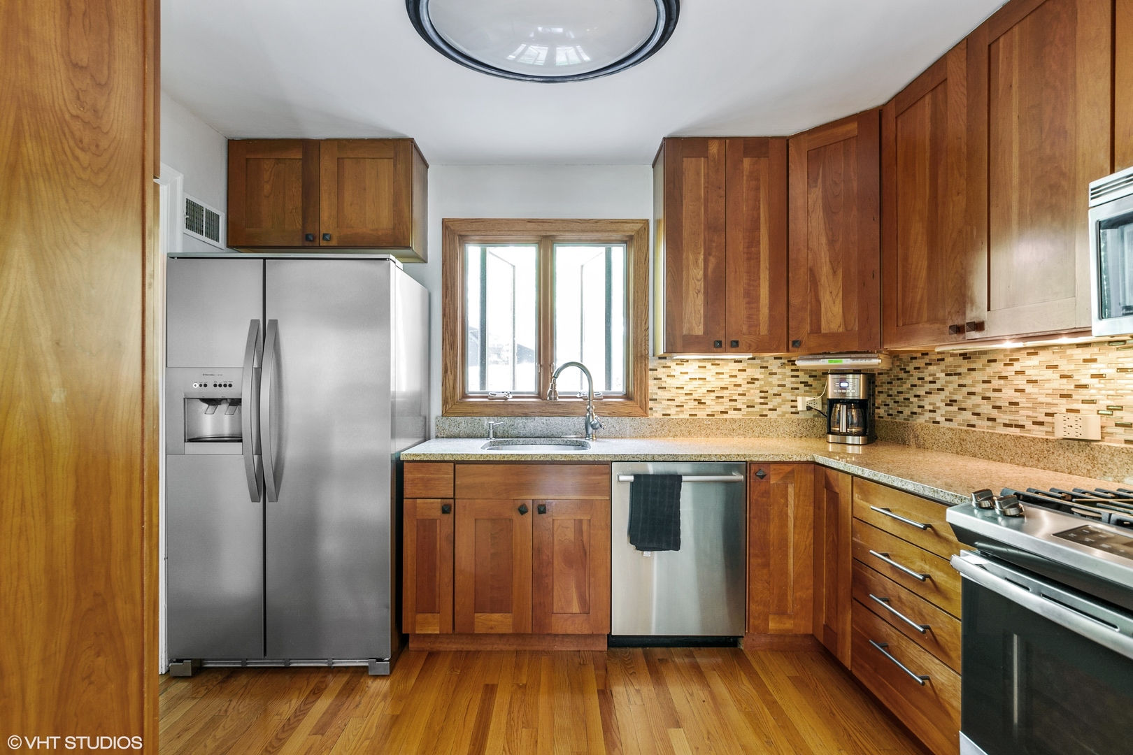 181 Ridge Road Highland Park, IL 60035 - Photo 5 of 16 a kitchen with stainless steel appliances granite countertop a refrigerator a sink dishwasher and wooden cabinets with wooden floor